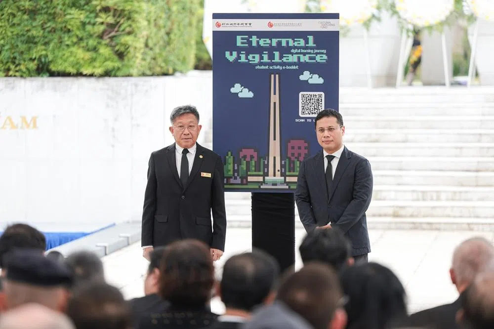 教育部长李智陞（右）在2月15日的公祭活动上，也主持了“居安思危：数码学习之旅”（Eternal Vigilance: Digital Learning Journey）电子手册的发布。