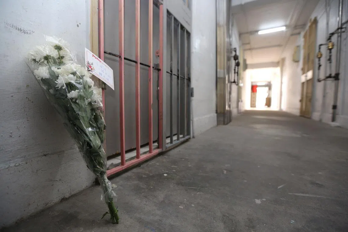 发生铁锅煮尸骸的振瑞路组屋人去楼空，有公众到该组屋单位外献花安抚死去的两岁半小女孩。（联合晚报）