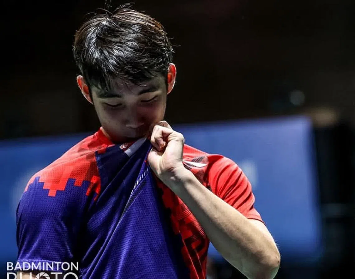 骆建佑在赢球后下意识地拉起球衣，亲吻胸前的新加坡国旗标志。(Badmintonphoto﻿）