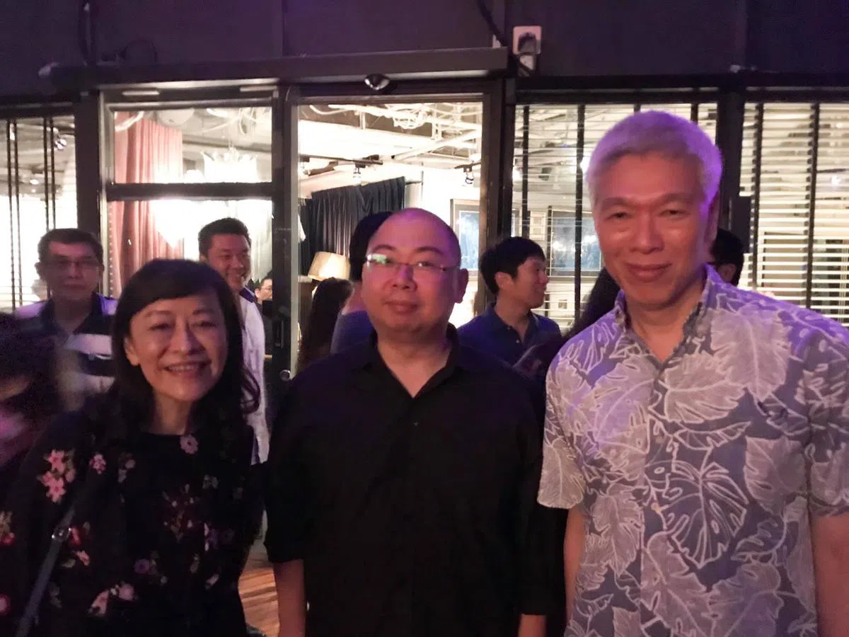  李显扬（右）和妻子林学芬（左）在募款晚会上和许渊臣（中）合照。（许渊臣面簿） 