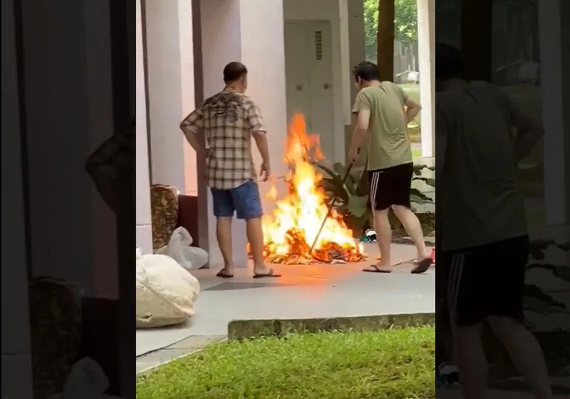 近日流传的一段视频显示两名男子在组屋底层焚烧冥纸。（视频截图）