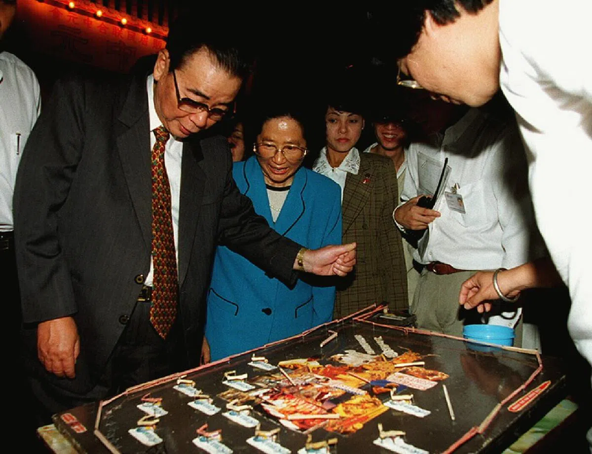  看到本地上世纪60年代盛行的Tikam Tikam抽签赢奖活动时，李鹏眼睛都亮了起来，十分感兴趣。64岁的李鹏试了试手气，结果手中的弹珠竟滑出游戏版外，在场的人都哄堂大笑，以为李鹏总理就此放弃。没想到他却坚持再试试运气，这次手中的弹珠滑到了一份奖品的位置。李鹏非常高兴，童心未泯的他又再次掷出弹珠，也再次“赢奖”，运气很不错。（新报） 