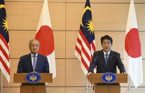 马来西亚新首相马哈迪（左）6月12日访问日本时会见了日本首相安倍晋三。（中国报）
