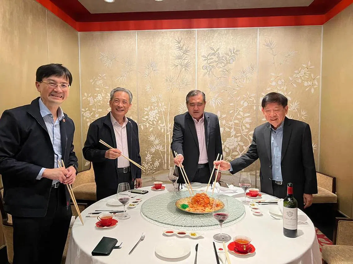 马国交长陆兆福（右二）和我国前交长许文远（右一）及SMRT主席佘文民（左二）捞鱼生。（陆兆福脸书）