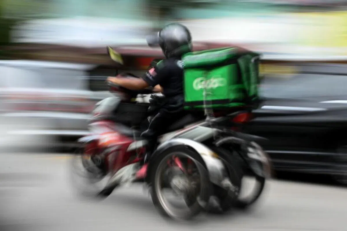  大学文凭一再贬值，很多人高不成只好低就，有的送外卖。（法新社） 