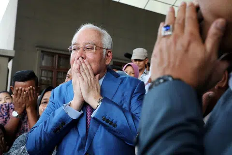纳吉在踏入法庭前与支持者一起祈祷。（法新社）