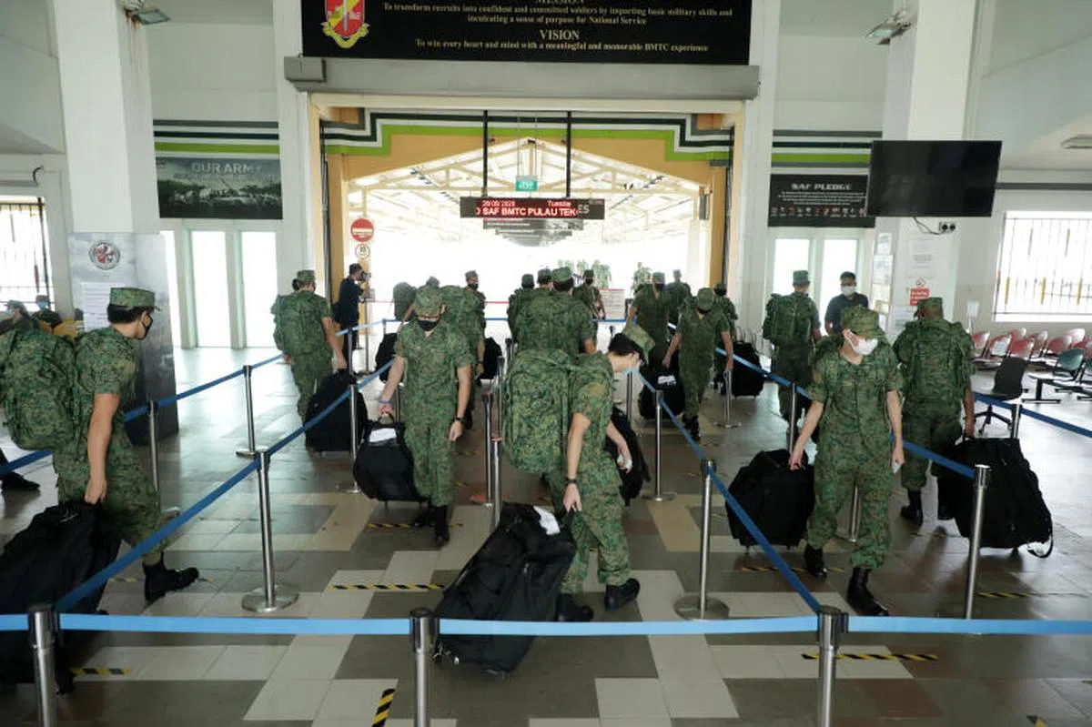 2020年5月26日，最早恢复基本军训的约1500名新兵错开时间回营报到，渡轮码头现场有军士和工作人员替他们量体温，并确保他们全程遵守安全距离。（联合早报）