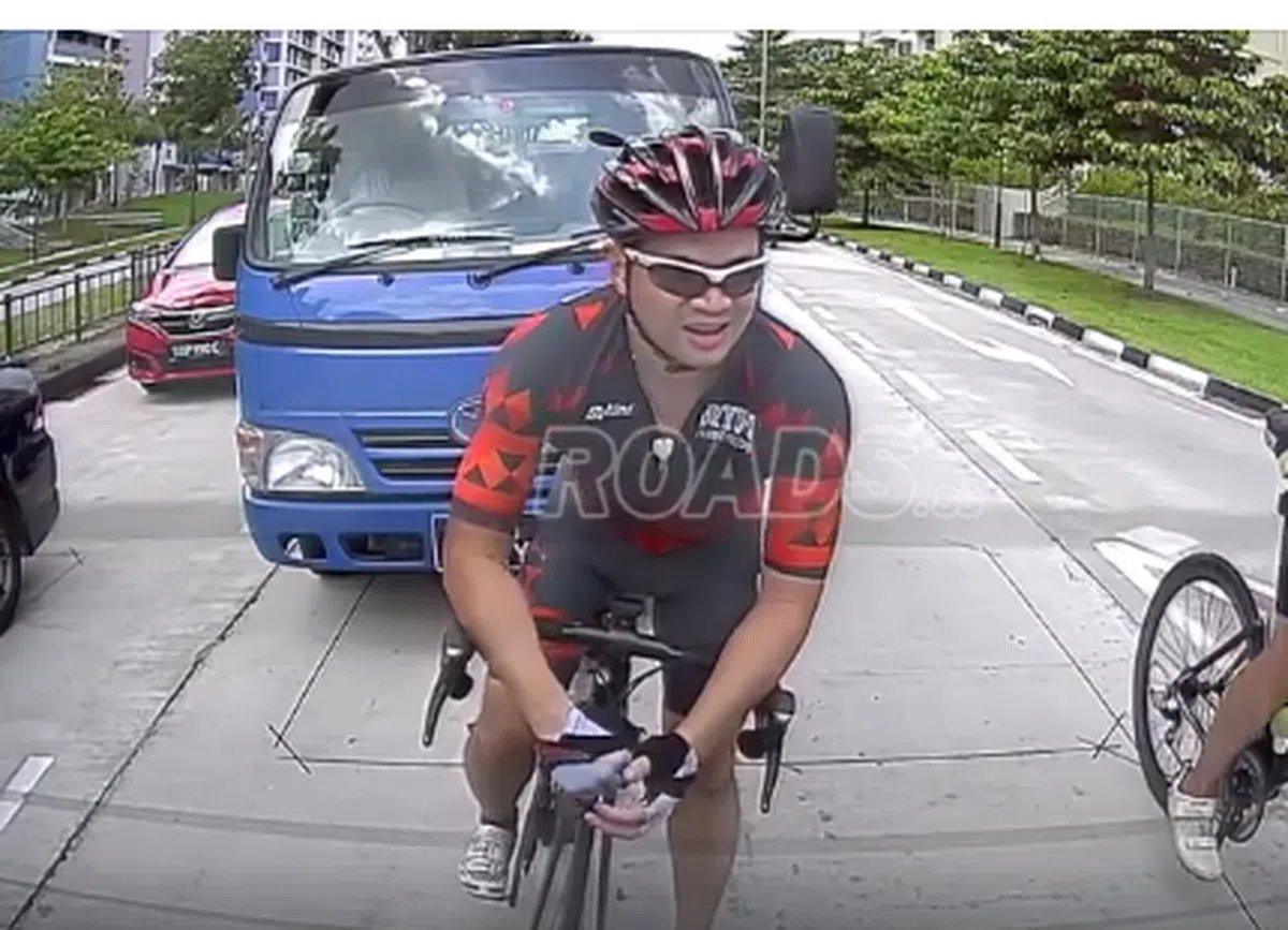  被后面那辆蓝色罗厘撞向路旁的脚踏车骑士。（Roads.sg截图） 