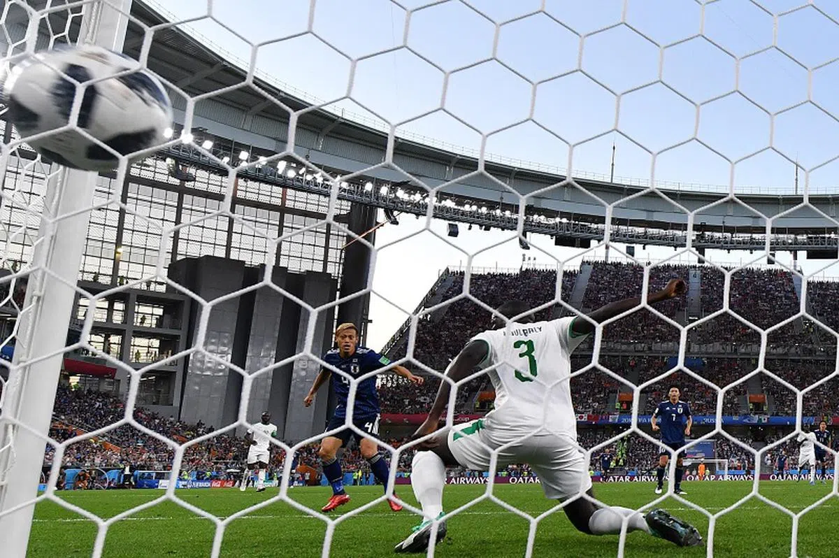  6月24日，日本队以2比2战平塞内加尔队。日本队球员本田圭佑（左）在比赛中进球瞬间。（新华社） 