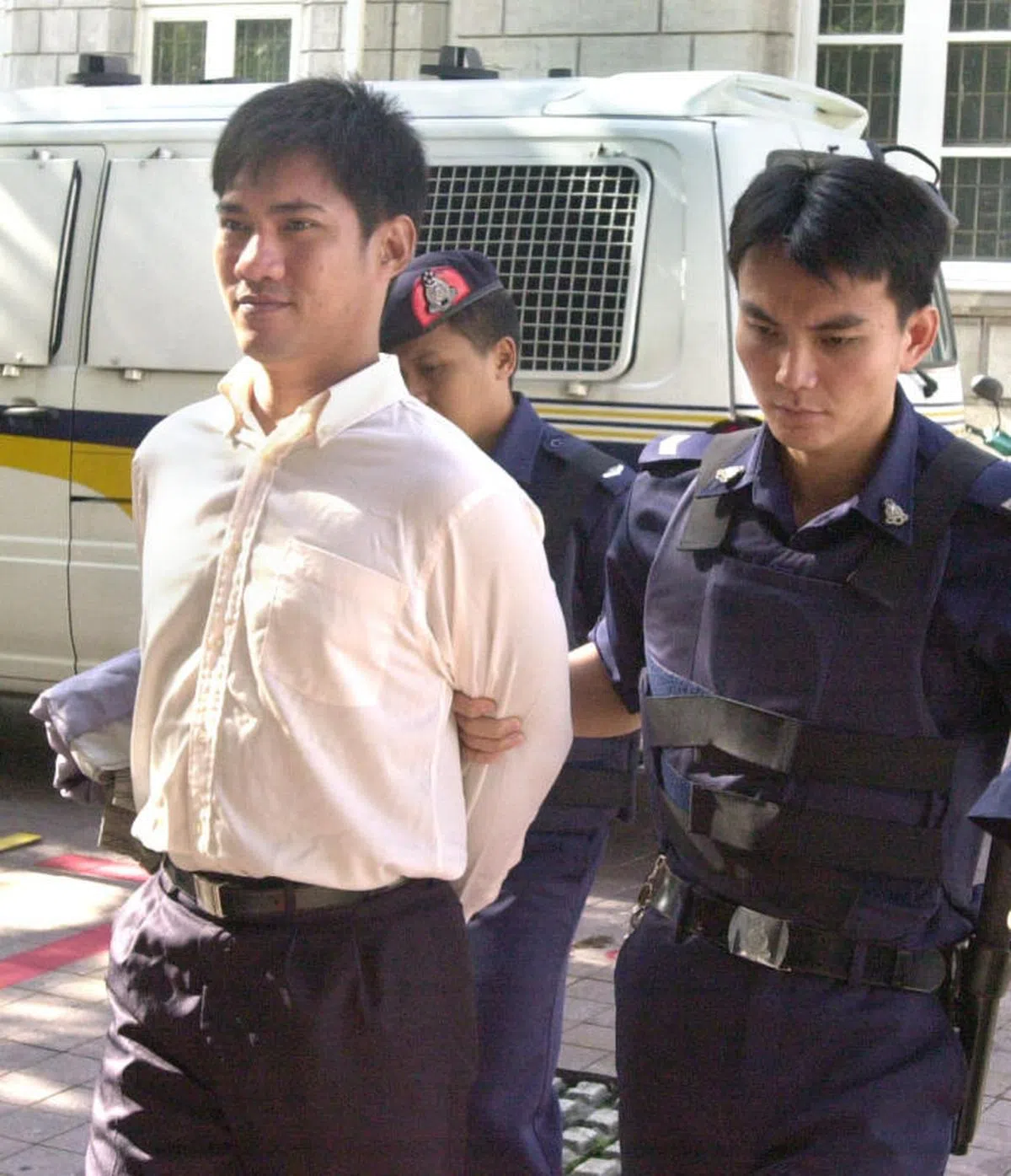  吕伟添抵达法院时脸上一直挂着招牌式的戏谑笑容。（新明日报） 