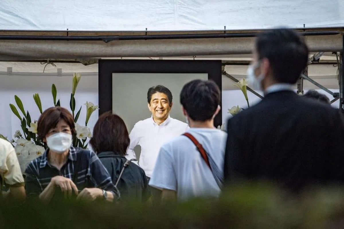 东京的增上寺摆放安倍遗照，大批民众到场献花。（法新社）