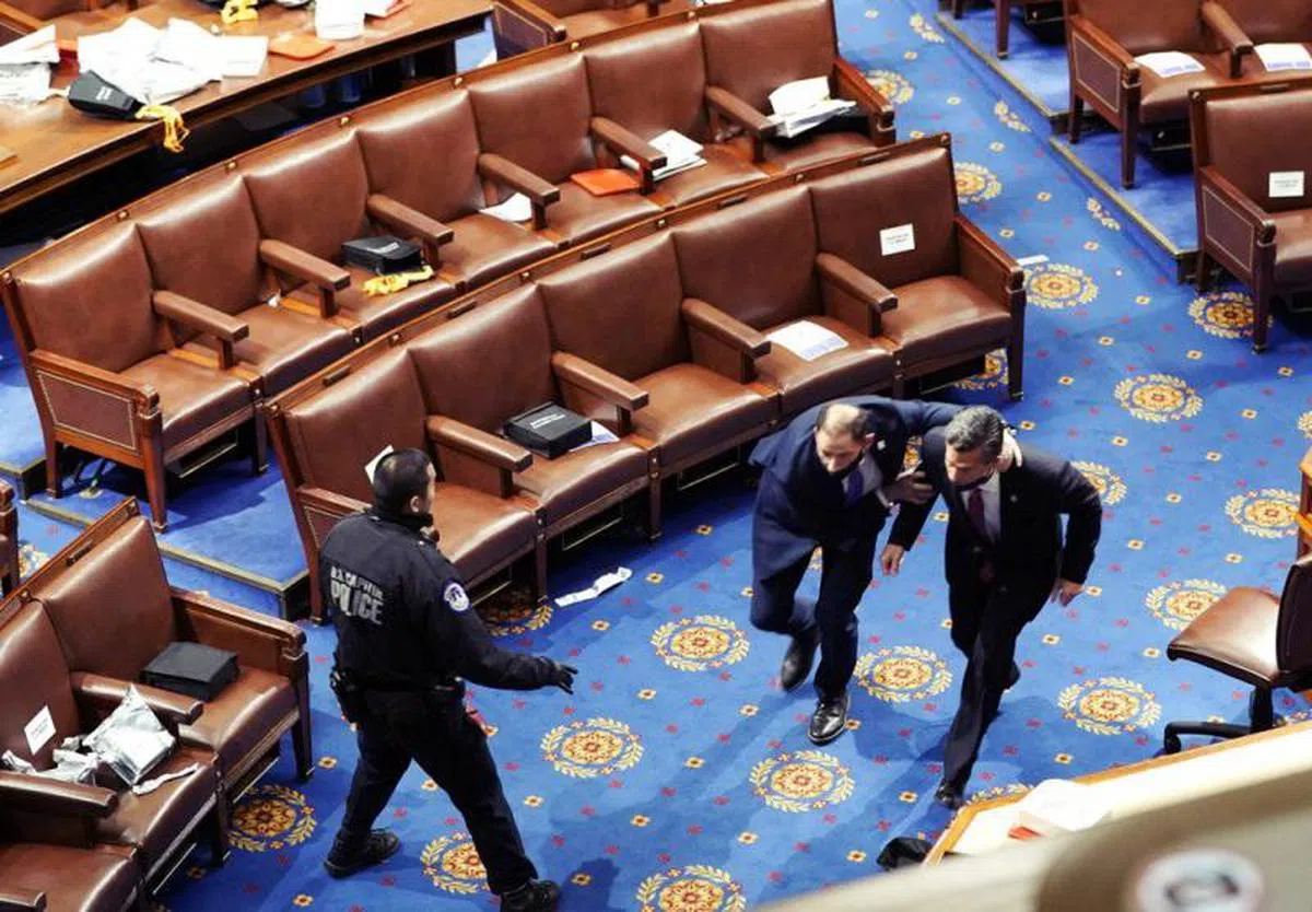  议员们在警察的护送下仓皇撤离。（法新社） 
