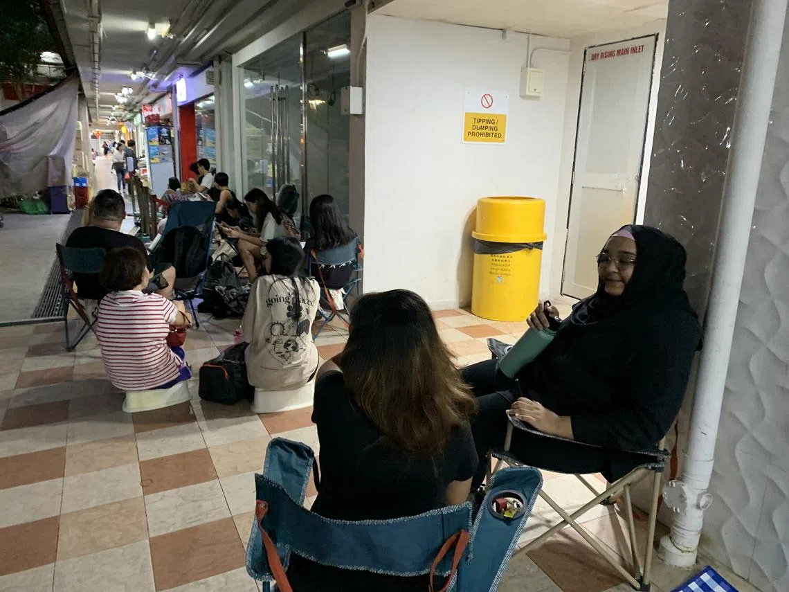 今晚8点，红蚂蚁办公室对面组屋楼下的邮政局外出现了30名霉粉。他们在通宵排队准备明天中午12点，在邮局购买泰勒丝2024年3月在新加坡举行的演唱会的门票。（红蚂蚁摄）