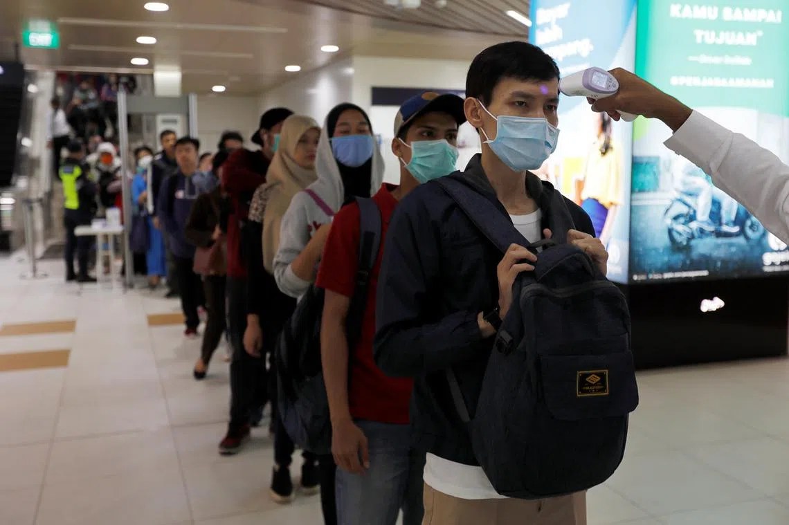 印尼出现第一起冠病确诊后，雅加达的地铁站开始为进站乘客测量体温。（路透社）