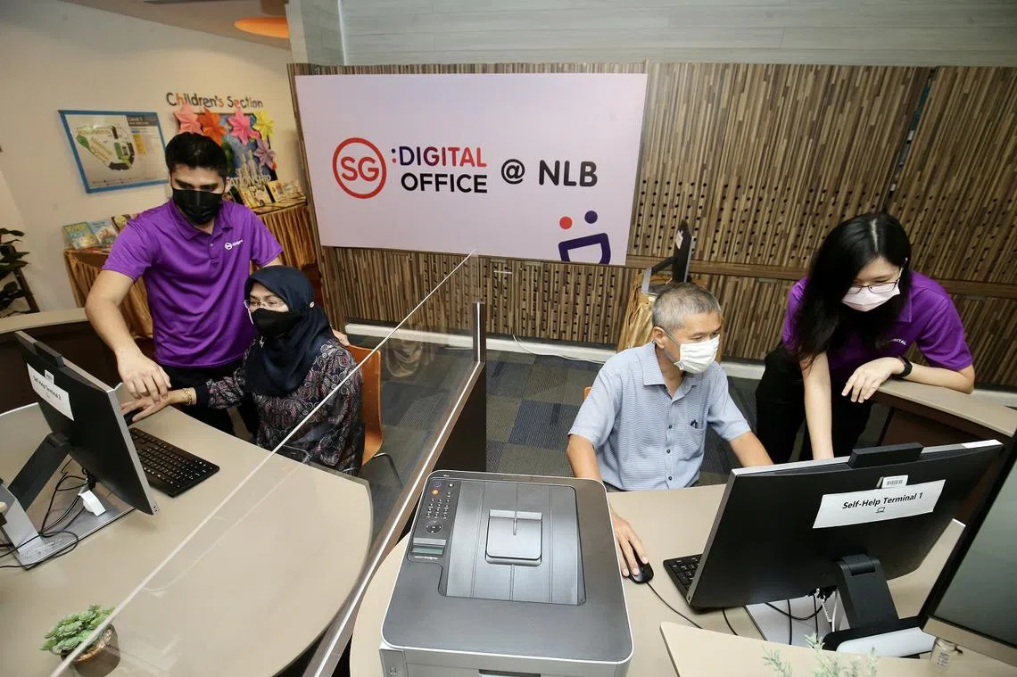 “数码大使”志愿者被调派到图书馆，一对一指导年长者使用电脑上网。（联合早报）