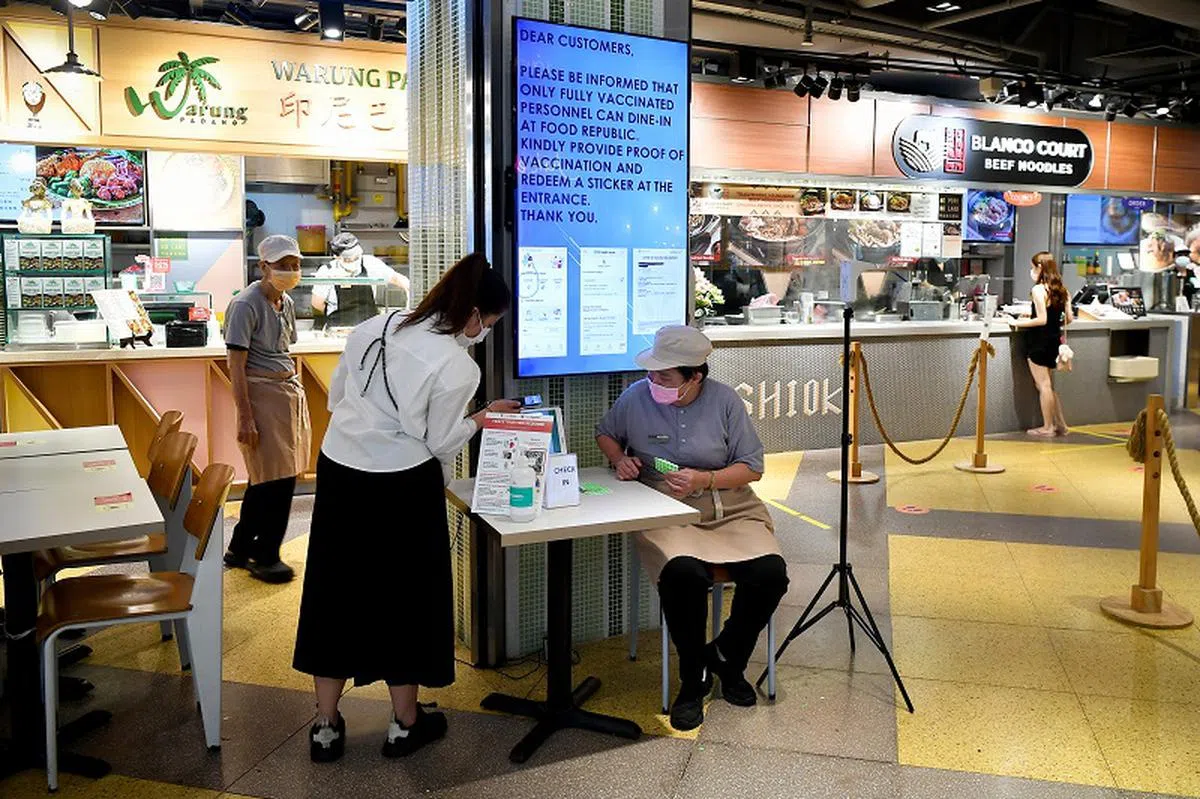 本地餐饮场所目前都在入口处派专人检查食客是否已经完成疫苗接种。（海峡时报）