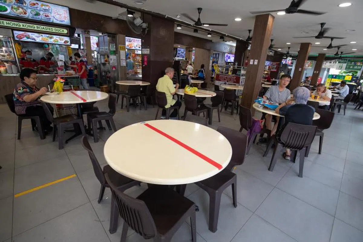  小贩中心和食阁的每组堂食人数上限为两人。（联合早报） 