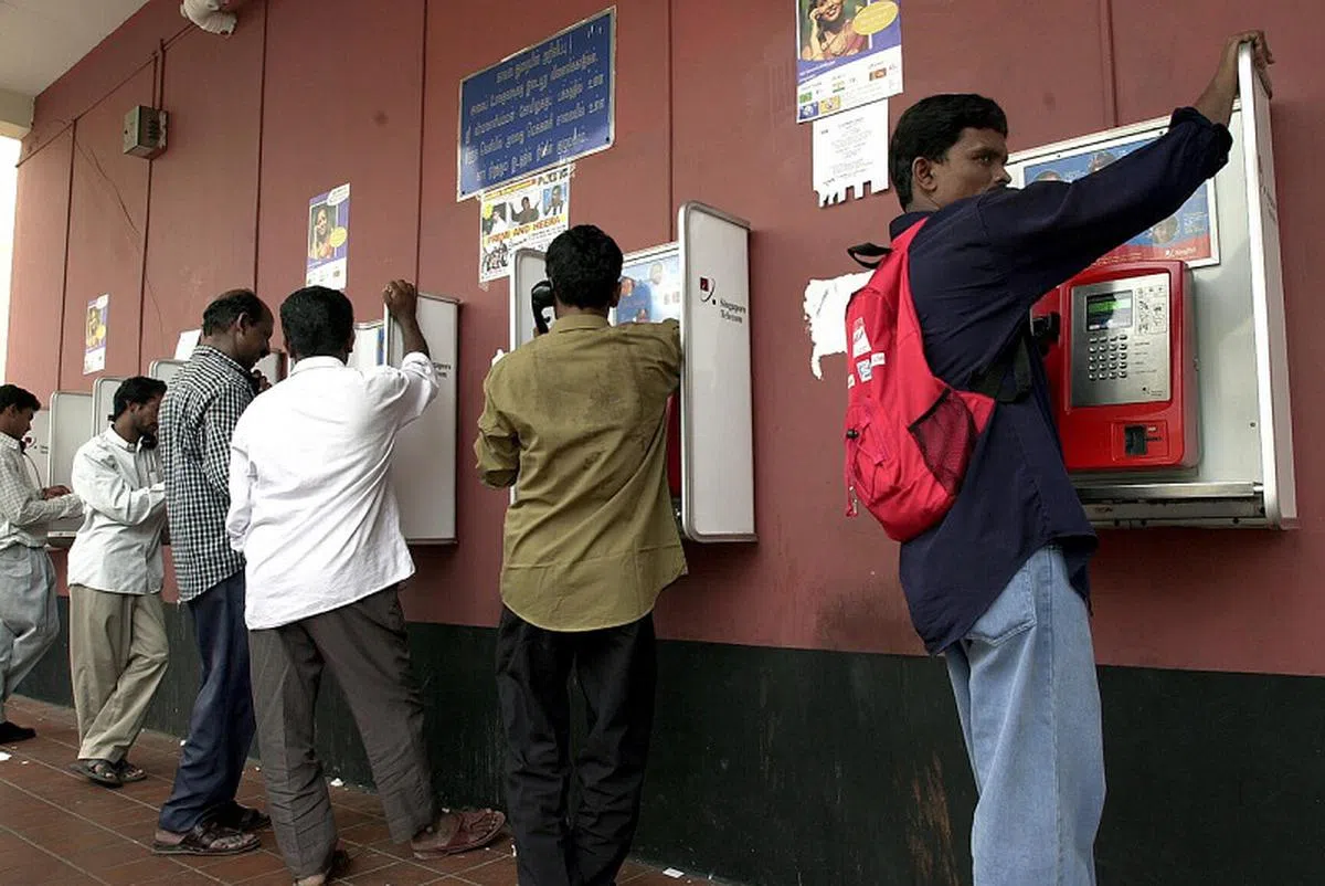 一些离乡背井的客工可能也还会使用公共电话联系家人。（联合早报档案照片）