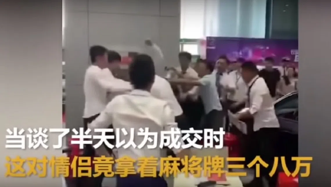 相传中国一对情侣为拍抖音用三个“八万”麻将牌去买车，被车行售货员群殴的现场。（视频截图）
