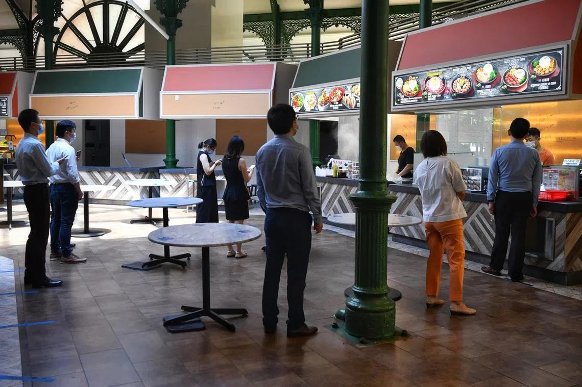 2020年6月2日，当局放宽部分冠病阻断措施后，老巴刹的顾客排队时保持安全距离，人人也戴着口罩。（海峡时报）