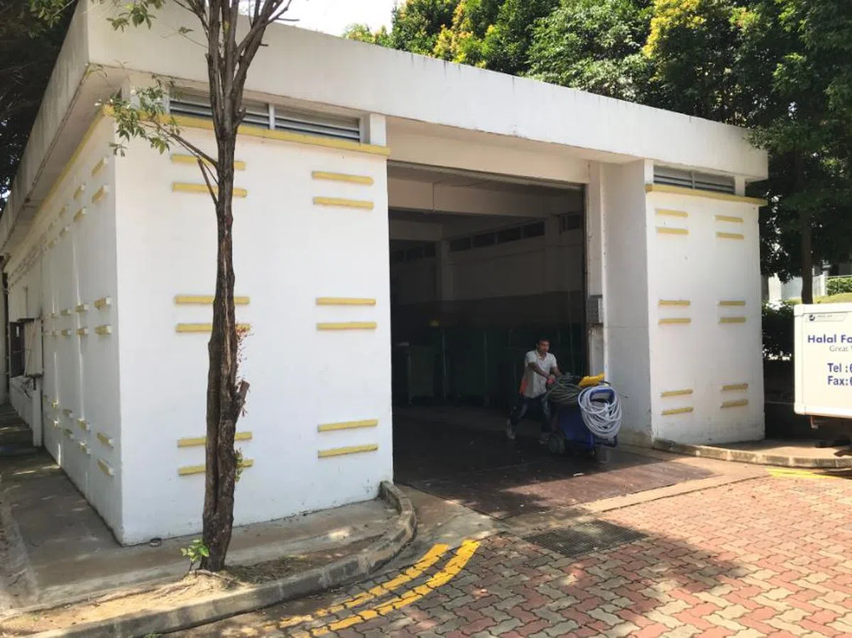  适逢工作时段，不时有工人推着清洗装备和垃圾桶进出垃圾收集站。（卢凌之摄） 