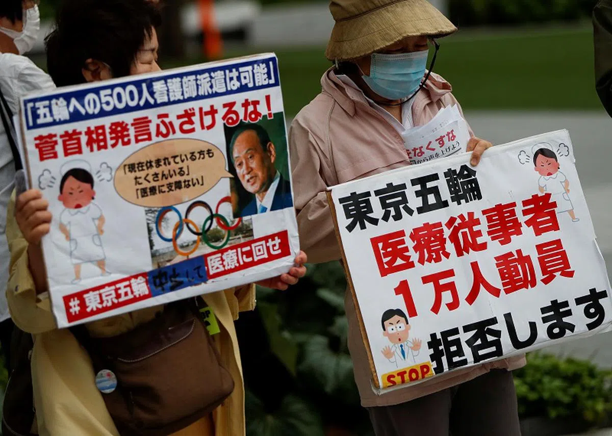  5月18日，日本民众在东京奥运组织委员会办公室外举牌抗议，要求政府取消奥运会。（路透社） 