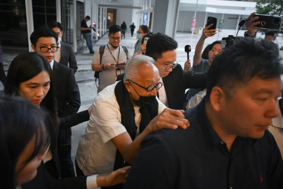 王明星今早抵达法庭，戴着口罩以及围着围巾，扶着陪同人员的肩膀与手臂缓步前行。（海峡时报）