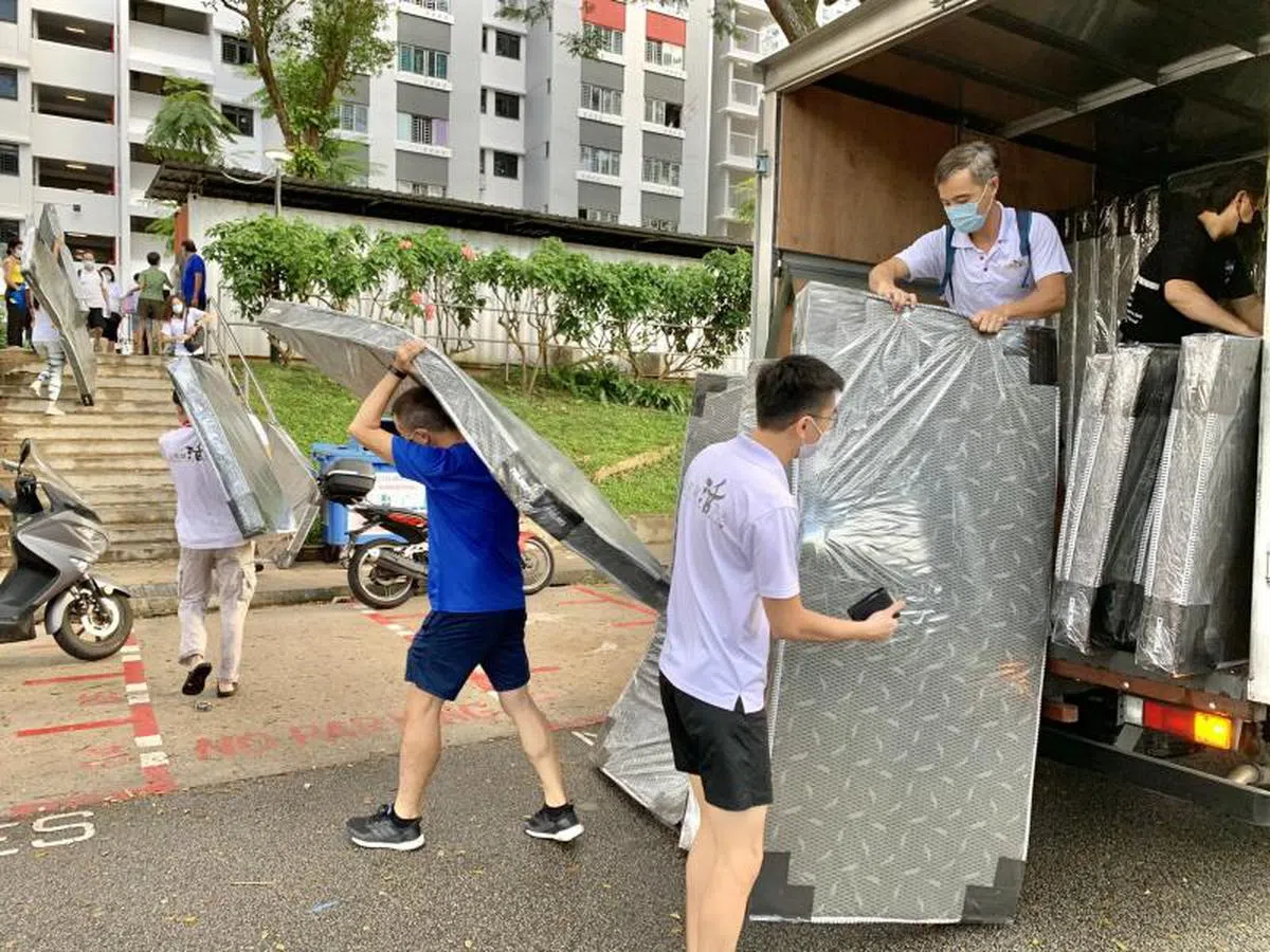  义工们挥洒汗水搬运床褥。（Lee Siew Yian面簿） 