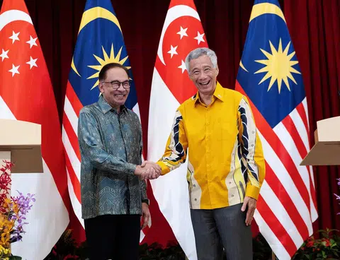 李显龙总理与马来西亚首相安华（左）在新马领导人非正式峰会记者会后亲切握手。（路透社）