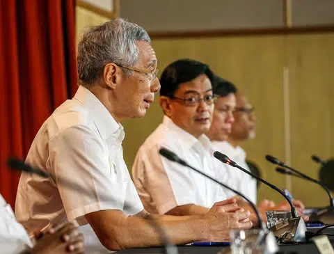 李显龙总理（左一）以行动党秘书长身份7月11日凌晨召开记者会总结大选选情。（联合早报）