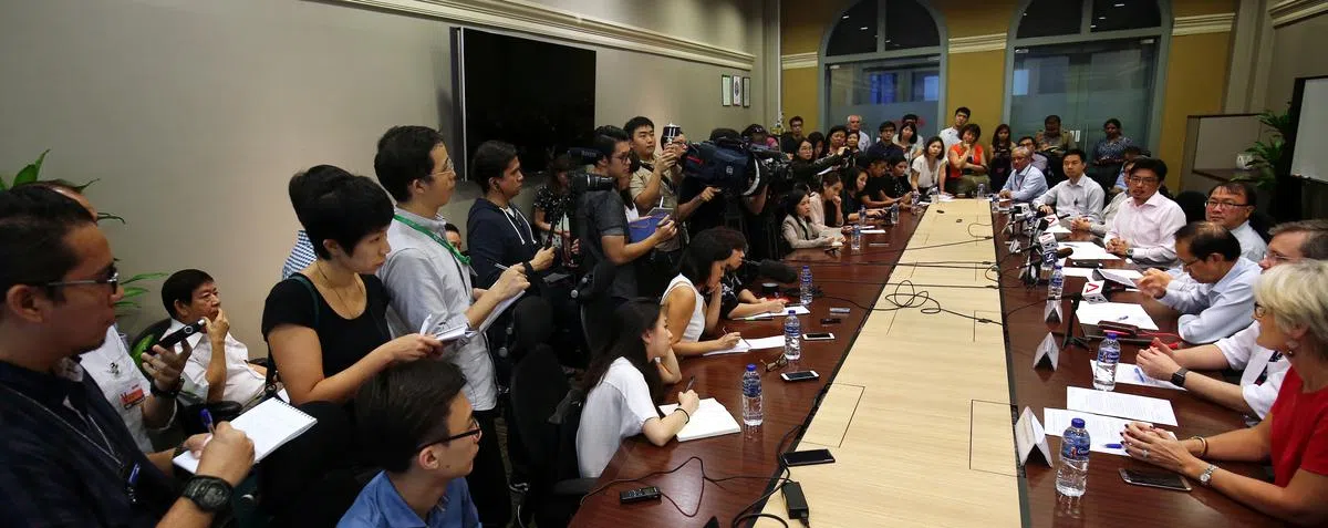  陆路交通管理局、SMRT和信号系统供应商泰雷兹（Thales）傍晚召开记者会，汇报初步调查结果。基础建设统筹部长兼交通部长许文远（后座左一白衣者）也出席了记者会，不过他坐在后座与媒体一起旁听汇报。（联合早报） 