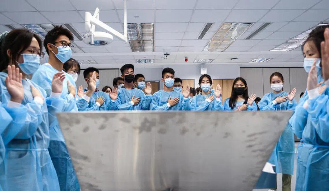 新加坡国立大学杨潞龄医学院在每个学期的解剖课开课前，学生都会站在每个“无语良师”的身旁默哀、宣誓。（联合早报）