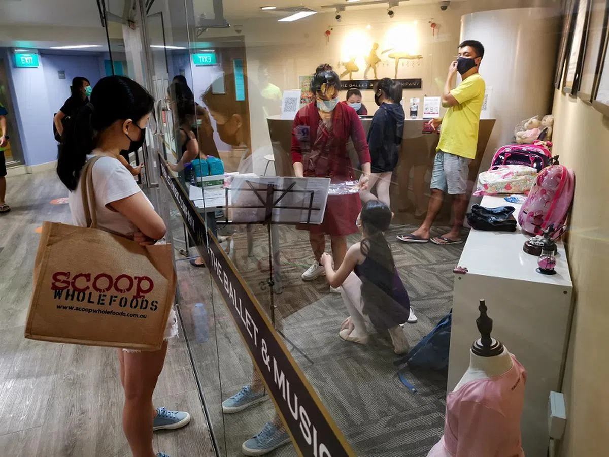 有家长担心是否需要为孩子的增益课程费用掏出更多钱。图为本地家长等候在上增益课程的孩子。（海峡时报）