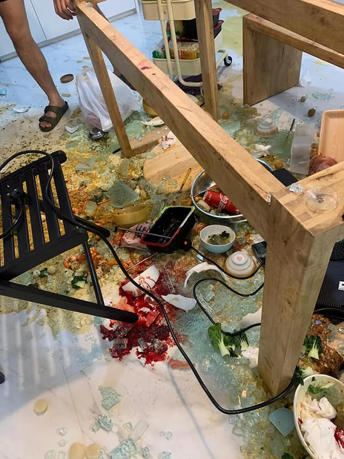  玻璃碎满地，掺杂着还未来的吃的食物和鲜血。（Stephanie Chu面簿） 