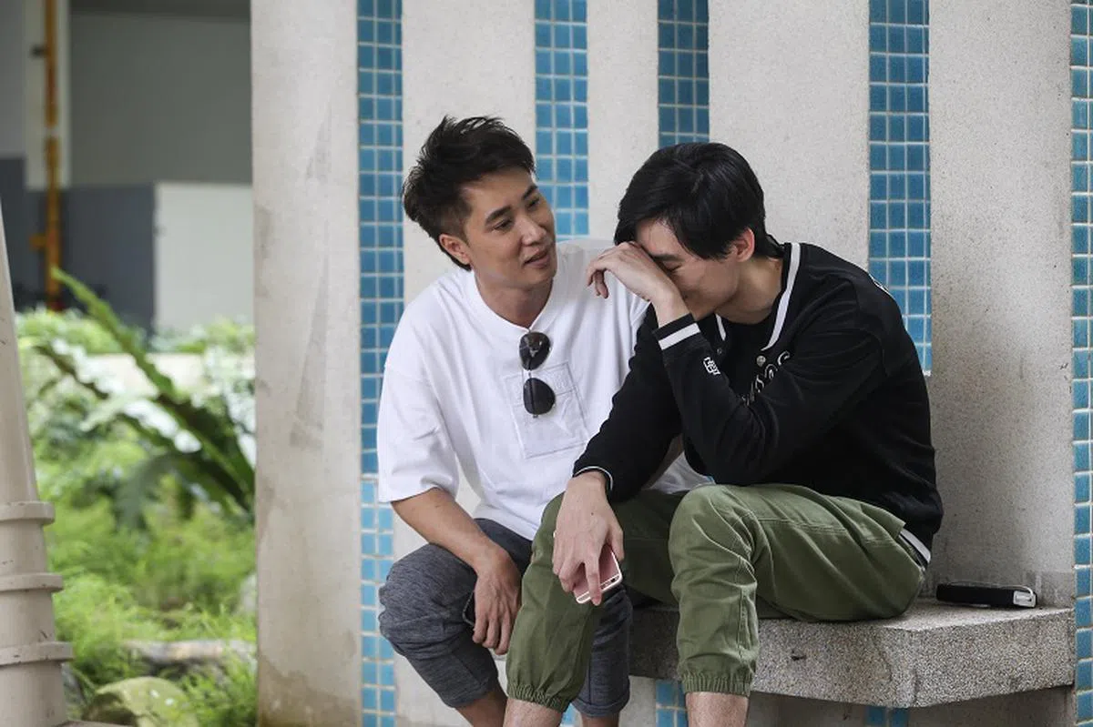  冯伟衷的哥哥冯伟哲（右）出发到新西兰前心情焦虑，许振荣在一旁安慰他。（联合晚报） 