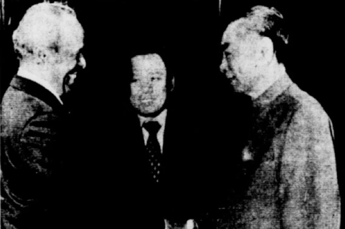 1975年3月16日，时任新加坡外长拉惹勒南（左）与时任中国总理周恩来（右）在北京握手言欢，在场的还有时任外交部高级政务部长李炯才（中）。据《南洋商报》报道，北京人民日报和光明日报都以显著的封面版位刊登这张照片。（NewspaperSG截图）