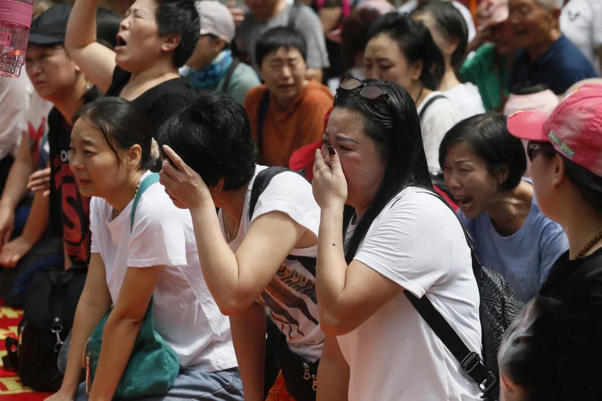  受害者们在大使馆外情绪激动，一些人歇斯底里地哭个不停，一些高唱中国国歌。（东方日报） 