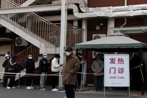 中国各地的发热门诊部门近日都排起了长长人龙。图为北京市民排队等候看诊。（路透社）