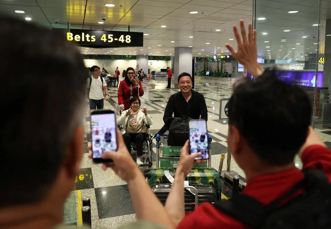 3月7日，兴奋的家属一面向从中东乘搭撤侨班机返回新加坡的亲人挥手，一面拍下感人的一幕。