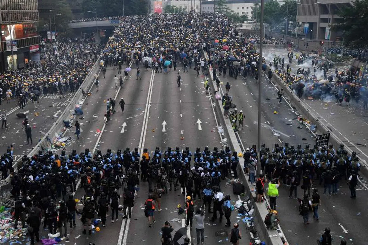 6月12日，香港“反送中”运动升级，警方向冲击封锁线的抗议民众发射催泪弹、布袋弹和橡胶弹。（法新社） 