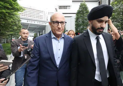 前交通部长易华仁1月18日在庭上表明不认罪后，在律师的陪同下离开国家法院。（联合早报）