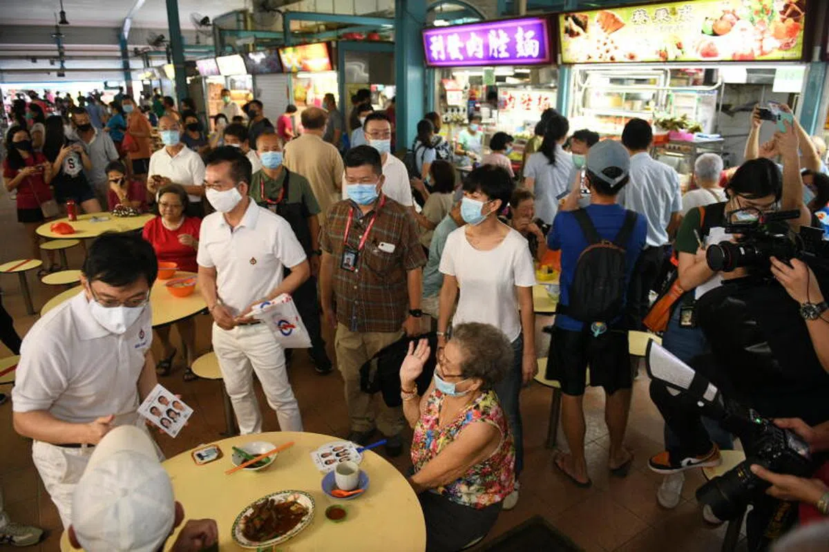  由副总理兼财政部长王瑞杰（左一）领军的东海岸行动党团队走访新樟宜路上段的熟食中心。（联合早报） 