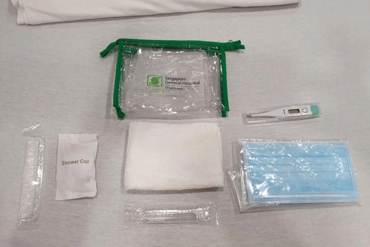  每个病人入住时会收到一个包，里头装有温度计、口罩和洗漱用品。病人也会收到一个装有饮料和零食的护理包。（海峡时报） 