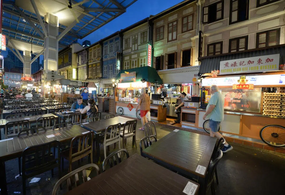  牛车水美食街显得冷清，员工积极招客。（新明日报） 