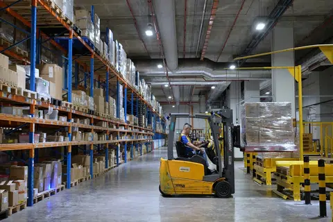 工作人员将数箱白米移到仓库里的货架上。