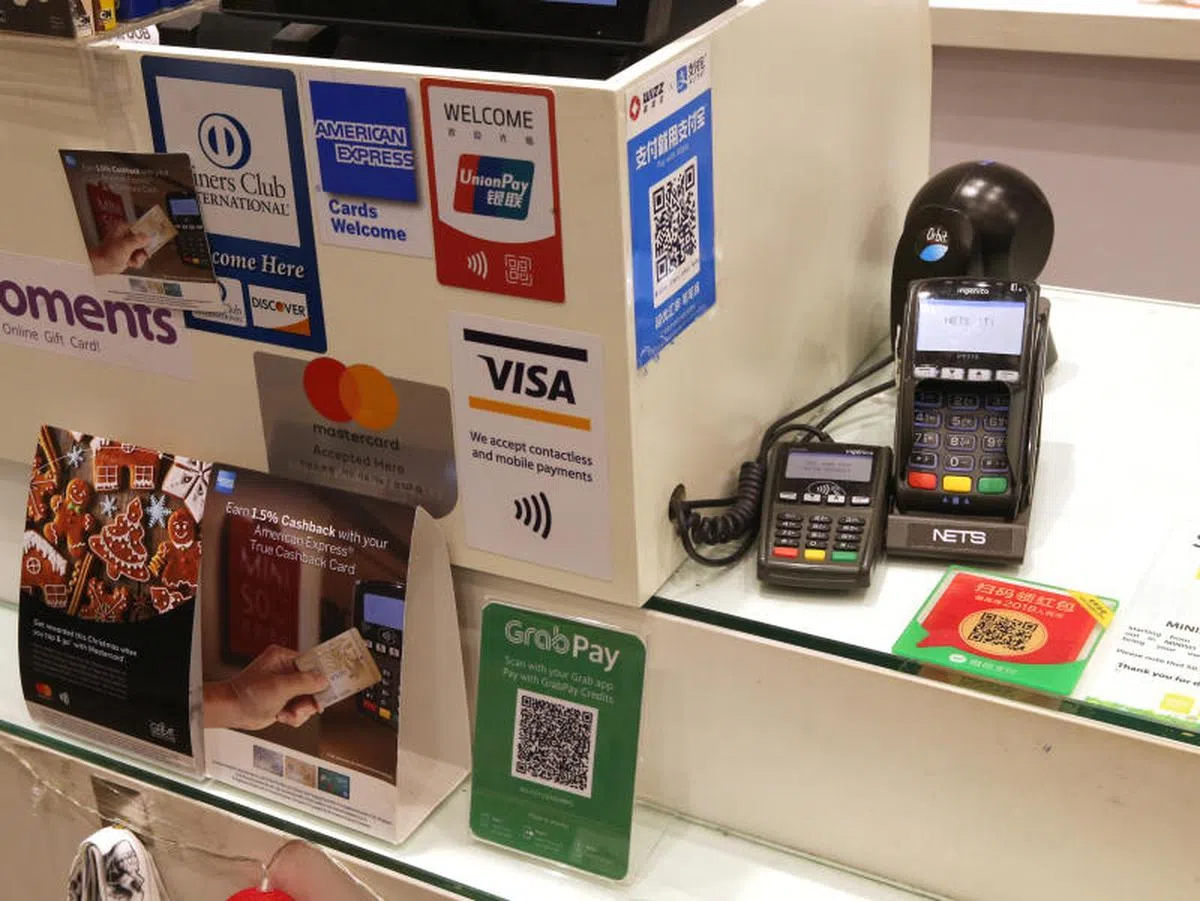  在零售商店柜台上，现在都可看到不少无现金支付终端机、QR码和说明。（联合晚报） 