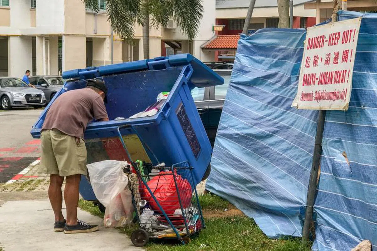  翻找垃圾、拾荒老人翻环保箱“挖宝”。（联合早报） 