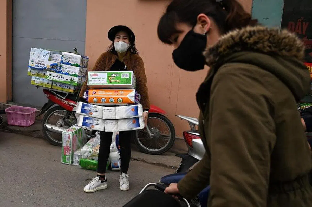  一名越南女子抢到了卫生纸，一脸的兴奋与满足。（法新社） 