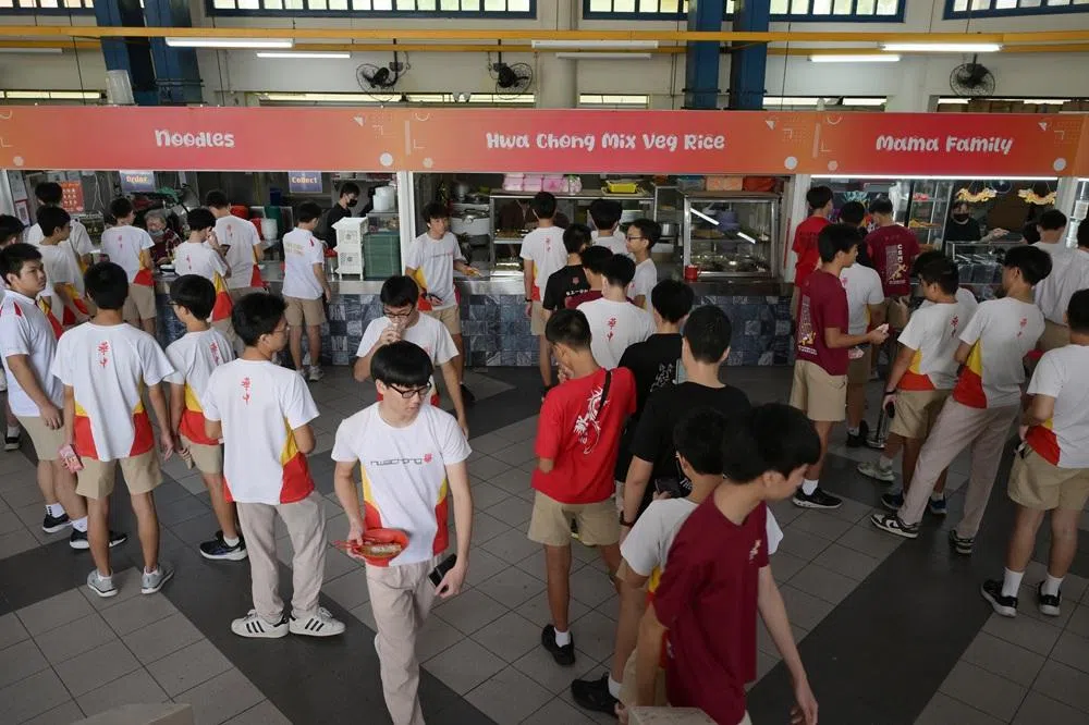 华中从2026年起和新翔集团（SATS）合作，推出餐食预购系统，旨在减少用餐等候时间。图为2025年10月17日，学生在华中初中部食堂排队买食物。