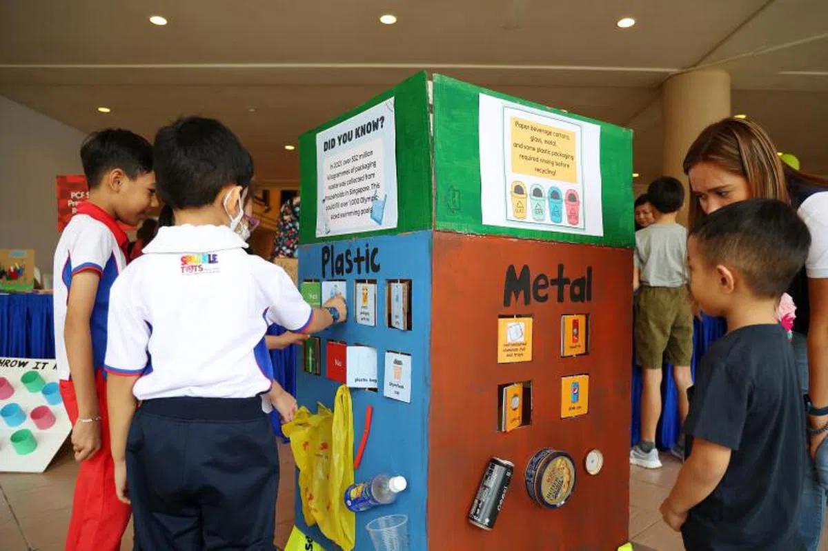 白沙—榜鹅区的学前孩童和小学生在“GREENWAVE”活动上，学习哪些材料和物品可以回收。（联合早报）